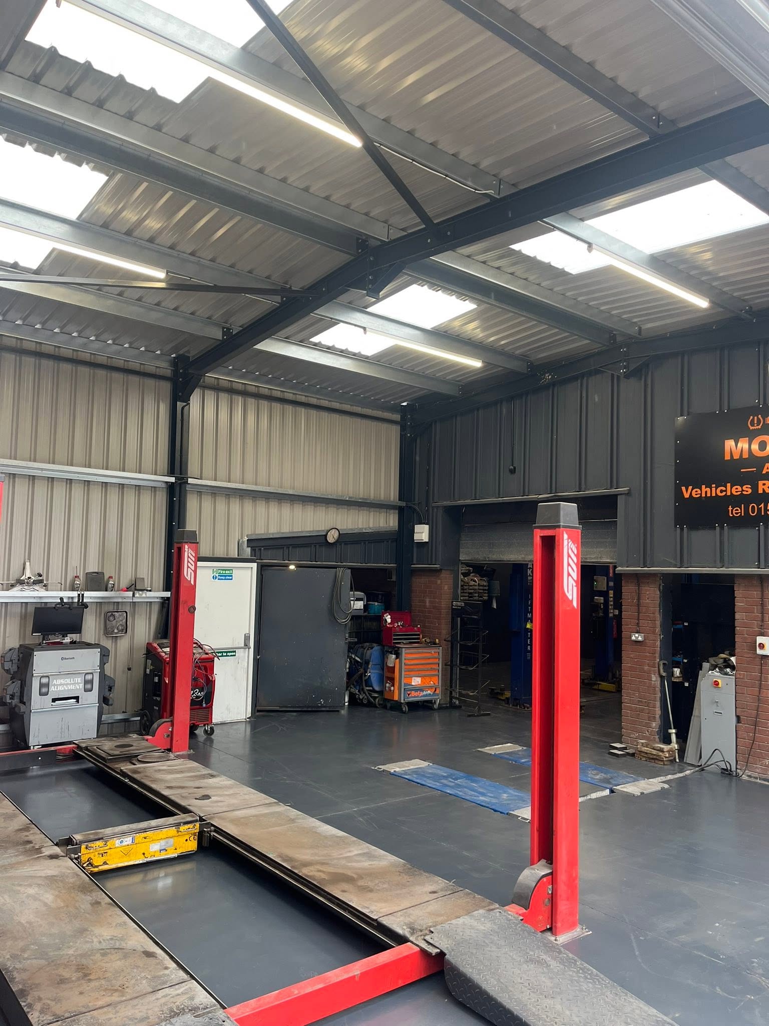 Red lift and MOT bay with the Morris Autos sign on the wall