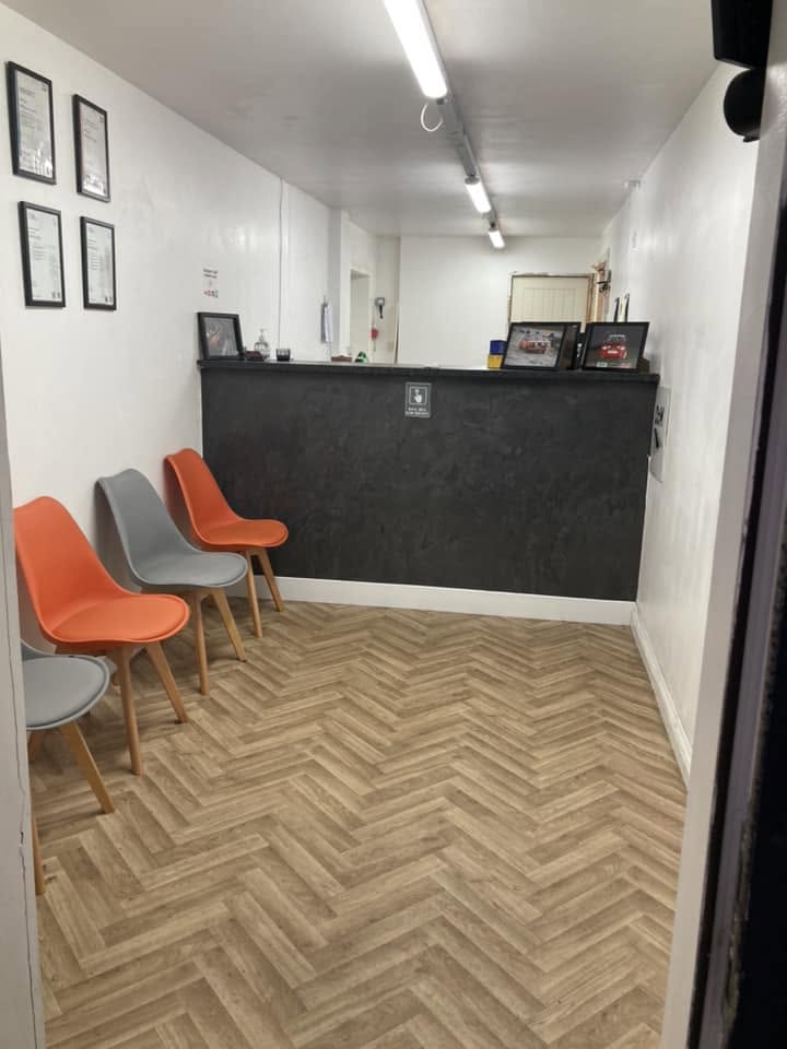 The reception and waiting area at Morris Autos with orange and grey chairs